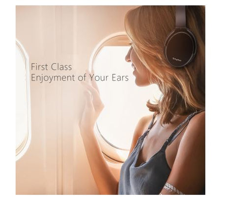 Woman in earplace near window enjoying fully the srhythm anc headphones